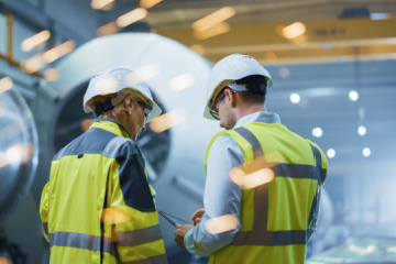 Two Heavy Industry Engineers Stand in Pipe Manufacturing Factory